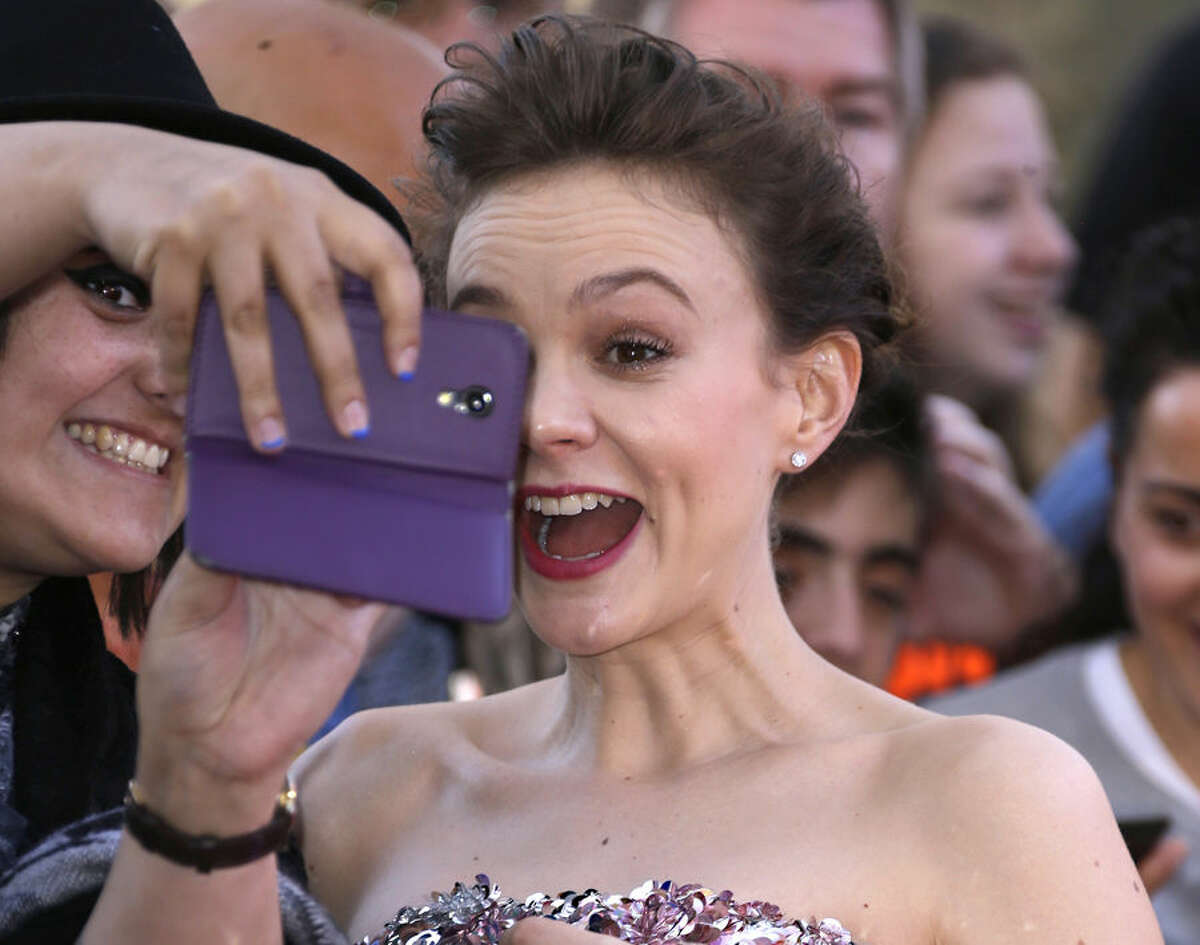 Actress Carey Mulligan reacts as she has a picture taken with a fan upon arrival at the the World premiere of the film Far From The Madding Crowd in central London, Wednesday April 15, 2015. (Photo by Joel Ryan/Invision/AP)