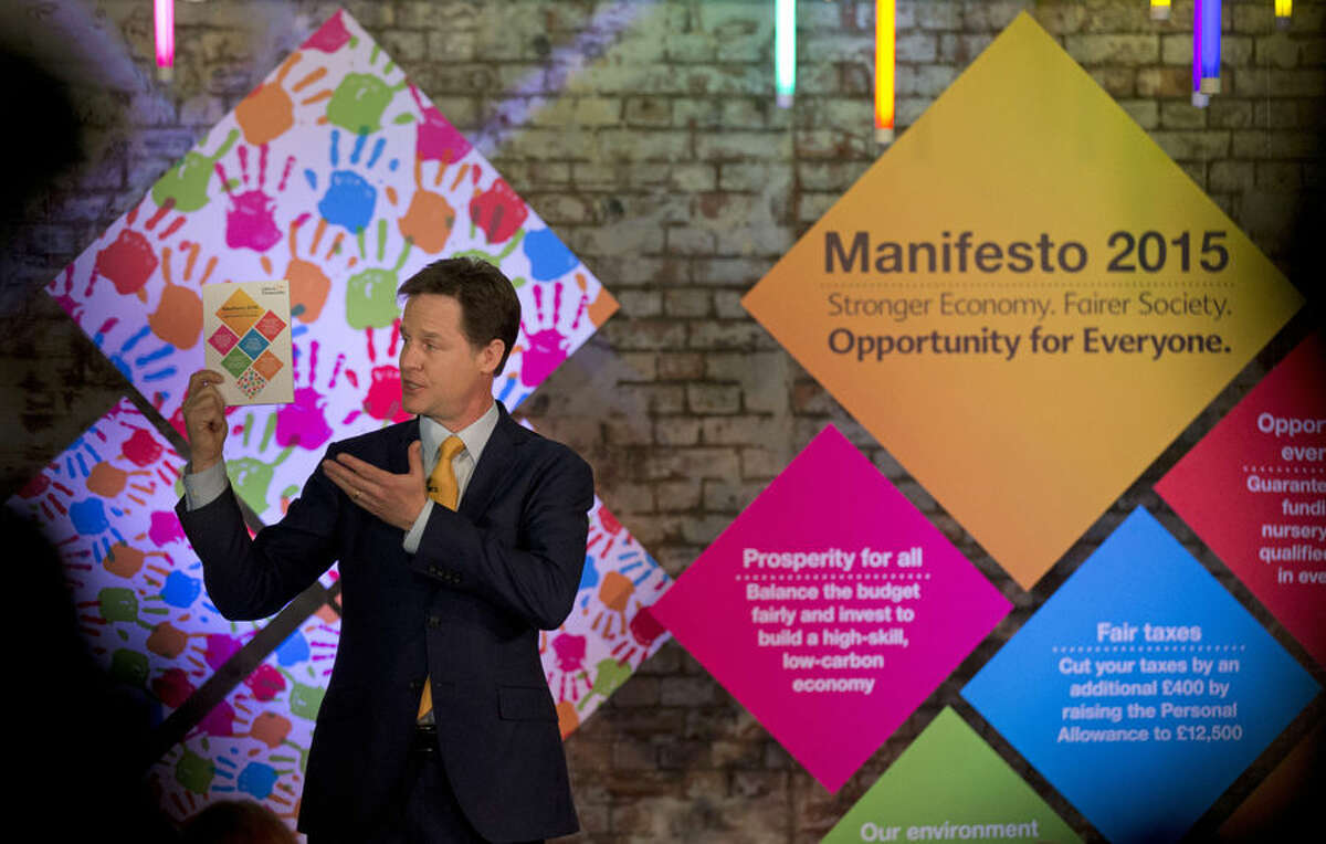 Nick Clegg the leader of Britain's Liberal Democrats party holds up a copy of his party's manifesto during its launch in London, Wednesday, April 15, 2015. Britain goes to the polls in a General Election on May 7. (AP Photo/Matt Dunham)