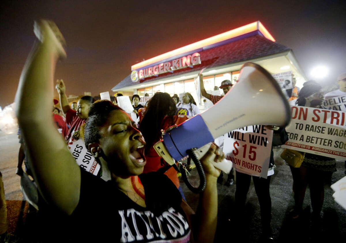 Carmen Burley-Rawls chants during a protest outside a Burger King restaurant by fast-food workers and activists calling for the federal minimum wage to be raised to $15, Wednesday, April 15, 2015, in College Park, Ga. Organizers say they chose April 15, tax day, to demonstrate because they want the public to know that many low-wage workers must rely on public assistance to make ends meet. (AP Photo/David Goldman)