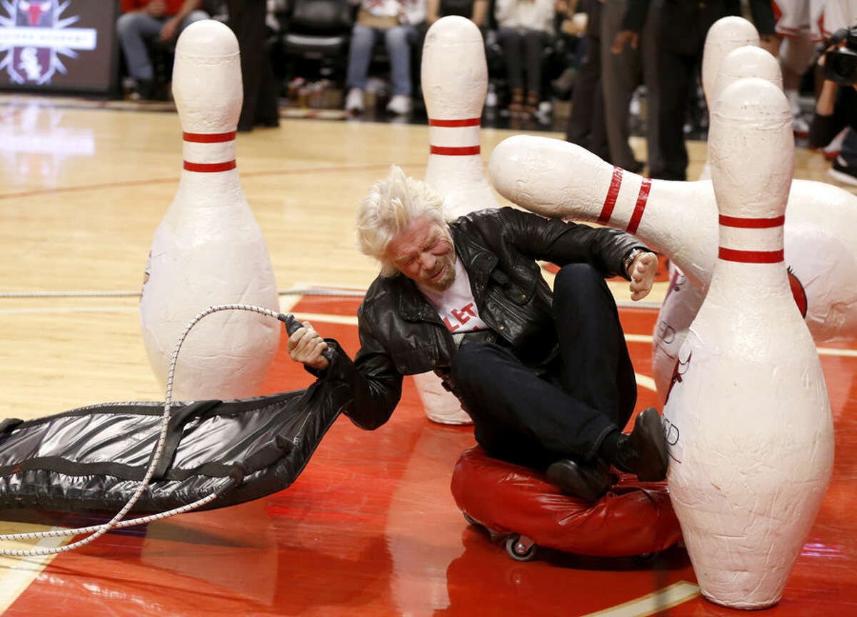 Sir Richard Branson participates in an on court stunt during the second half of an NBA basketball game between the Chicago Bulls and the Atlanta Hawks Wednesday, April 15, 2015, in Chicago. The Bulls won 91-85. (AP Photo/Charles Rex Arbogast)