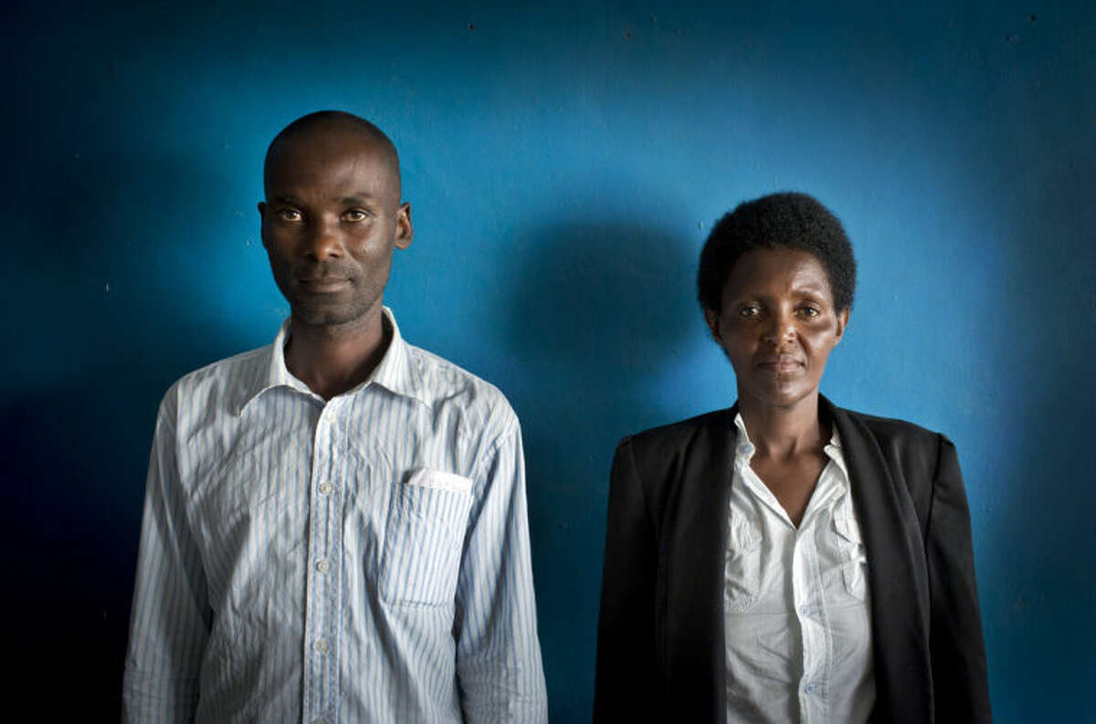 In this photo taken Wednesday, March 26, 2014, Emmanuel Ndayisaba, left, and Alice Mukarurinda, pose for a photograph at Alice's house in Nyamata, Rwanda. She lost her baby daughter and her right hand to a manic killing spree. He wielded the machete that took both. Yet today, despite coming from opposite sides of an unspeakable shared past, Alice Mukarurinda and Emmanuel Ndayisaba are friends. She is the treasurer and he the vice president of a group that builds simple brick houses for genocide survivors. They live near each other and shop at the same market. Their story of ethnic violence, extreme guilt and, to some degree, reconciliation is the story of Rwanda today, 20 years after its Hutu majority killed more than 1 million Tutsis and moderate Hutus. The Rwandan government is still accused by human rights groups of holding an iron grip on power, stifling dissent and killing political opponents. But even critics give President Paul Kagame credit for leading the country toward a peace that seemed all but impossible two decades ago. (AP Photo/Ben Curtis)