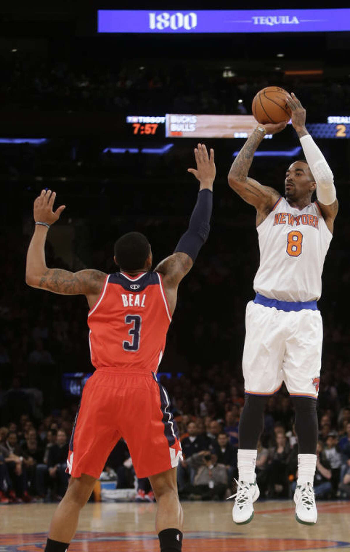 New York Knicks' J.R. Smith (8) shoots over Washington Wizards' John Wall (2) during the first half of an NBA basketball game Friday, April 4, 2014, in New York. (AP Photo/Frank Franklin II)