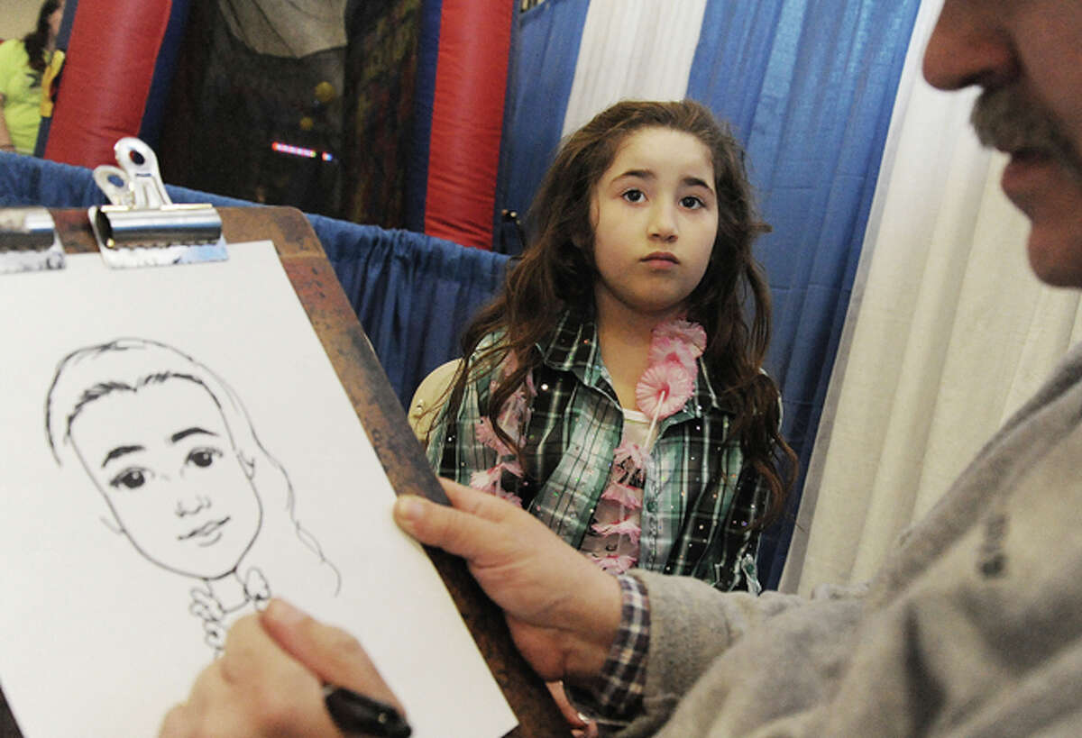 Leslie Rosara 7, getting her picture drawn by caricatures by Mike Valentine Sunday at the Kids Fest held in the Wilton High School field house. Hour photo/Matthew Vinci