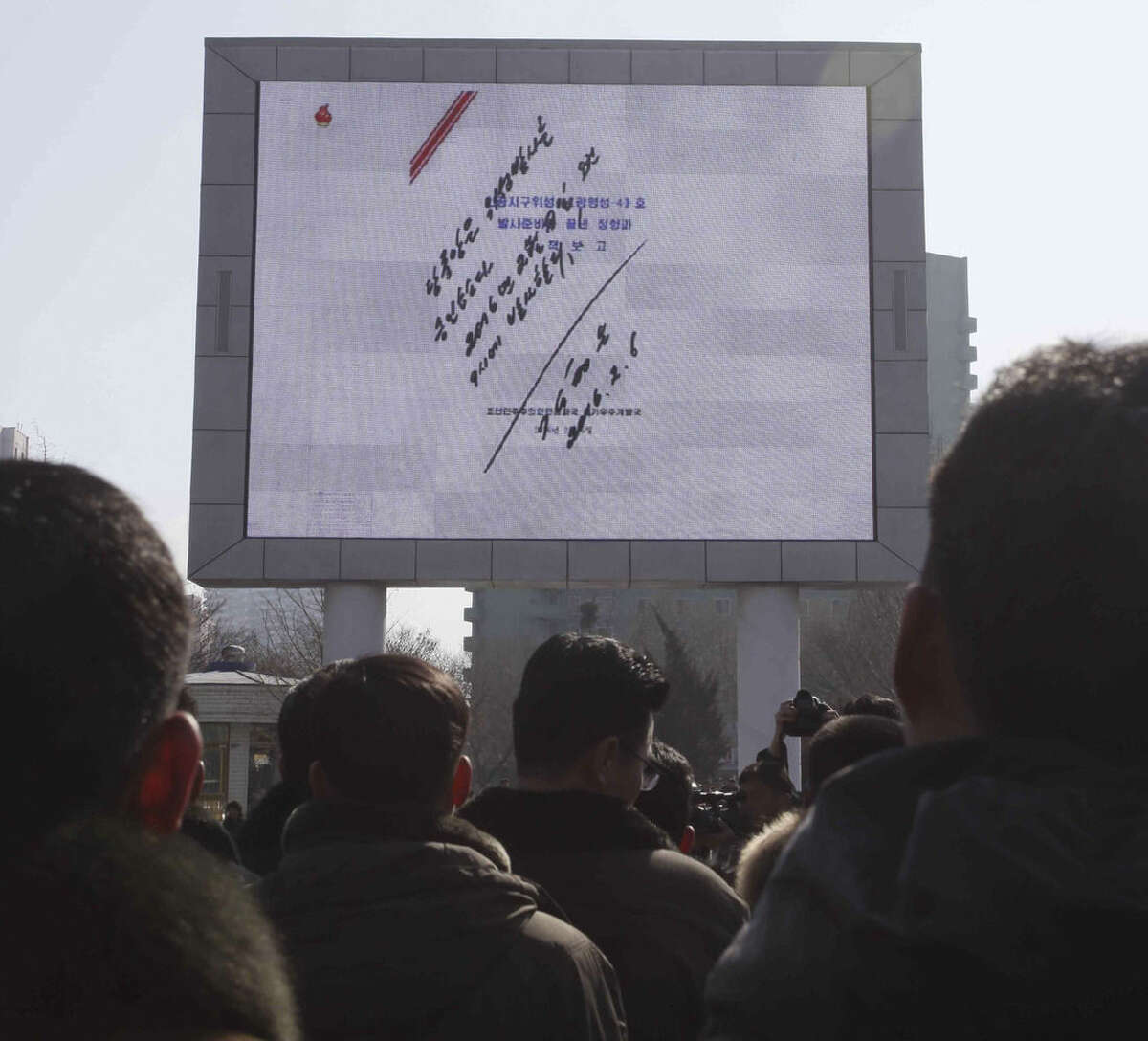 North Koreans watch an electronic screen showing a signed document by North Korean leader Kim Jong Un regarding the launch of a satellite on Sunday, Feb. 7, 2016, at the Pyongyang Railway Station in Pyongyang, North Korea. North Korea on Sunday defied international warnings and launched a long-range rocket that the United Nations and others call a cover for a banned test of technology for a missile that could strike the U.S. mainland. (AP Photo/Kim Kwang Hyon)