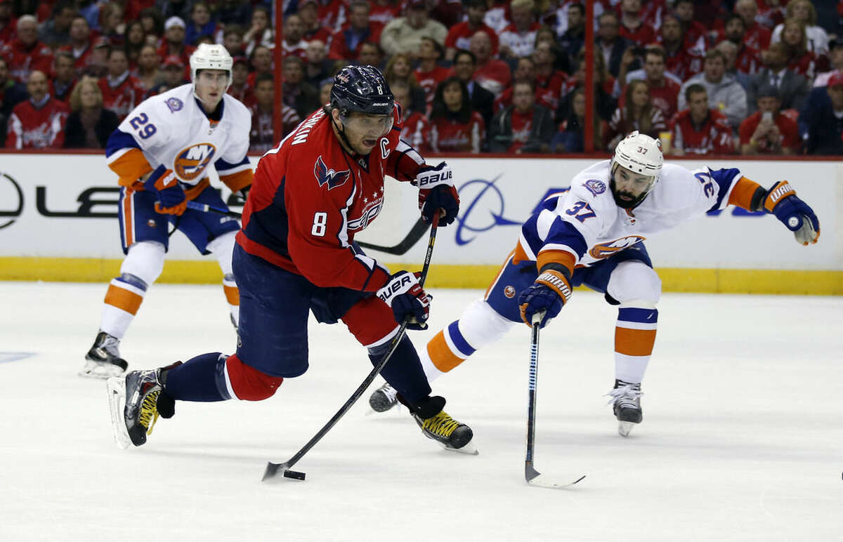 Washington Capitals left wing Alex Ovechkin (8), from Russia, shoots past New York Islanders defenseman Brian Strait (37) during the first period of Game 1 of a first-round NHL hockey Stanley Cup playoffs series, Wednesday, April 15, 2015, in Washington. (AP Photo/Alex Brandon)