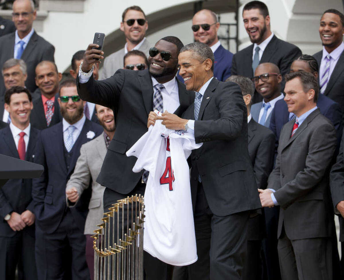 Boston Red Sox designated hitter David "Big Papi" Ortiz, left, takes a selfie with President Barack Obama, holding a Boston Red Sox jersey presented to the president during a ceremony on the South Lawn of the White House in Washington, Tuesday, April 1, 2014, where the president honored the 2013 World Series baseball champion Boston Red Sox. (AP Photo/Manuel Balce Ceneta)