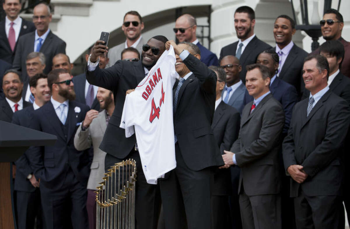 Boston Red Sox player David "Big Papi" Ortiz, left, takes a selfie with President Barack Obama, holding a Boston Red Sox jersey presented to the president during a ceremony on the South Lawn of the White House in Washington, Tuesday, April 1, 2014, where the president honored the 2013 World Series baseball champion Boston Red Sox. (AP Photo/Manuel Balce Ceneta)