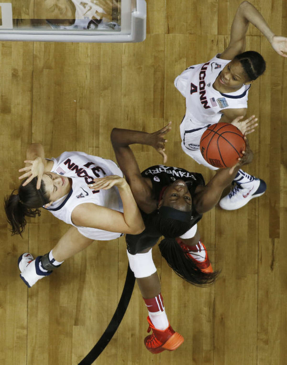 Stanford forward Chiney Ogwumike (13) works between Connecticut's Stefanie Dolson (31) Moriah Jefferson (4) during the second half of the semifinal game in the Final Four of the NCAA women's college basketball tournament, Sunday, April 6, 2014, in Nashville, Tenn. (AP Photo/John Bazemore)