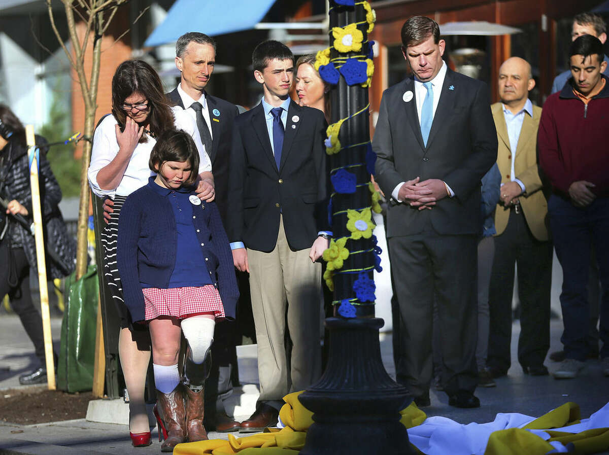 Boston Mayor Marty Walsh, right. looks down after Boston Marathon survivor Jane Richard, left, and her brother Henry removed a drape covering a memorial honoring victims and survivors at one of two blast sites near the finish line of the Boston Marathon in Boston, Wednesday, April 15, 2015. Parents, Bill and Denise Richards, back, stood by during the unveiling. Boston marked the second anniversary of the 2013 marathon bombings with a subdued remembrance that includes a moment of silence, the pealing of church bells and a call for kindness. The children lost their brother Martin Richard while standing with him during one of the explosions. (John Tlumacki/The Boston Globe via AP) BOSTON HERALD OUT, QUINCY OUT; NO SALES