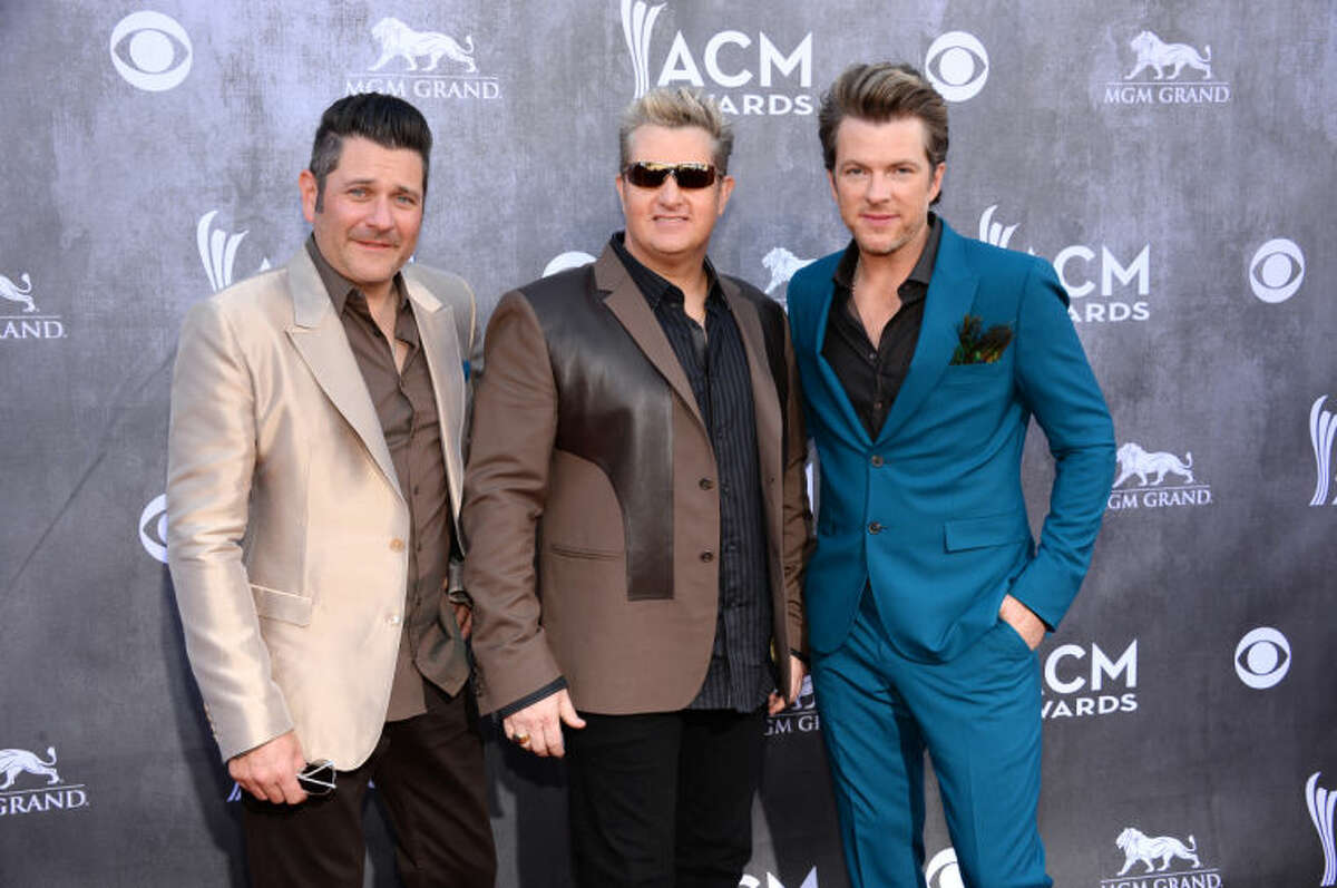 Jay DeMarcus, and from left, Gary LeVox and Joe Don Rooney, of the musical group Rascal Flatts, arrive at the 49th annual Academy of Country Music Awards at the MGM Grand Garden Arena on Sunday, April 6, 2014, in Las Vegas. (Photo by Al Powers/Powers Imagery/Invision/AP)