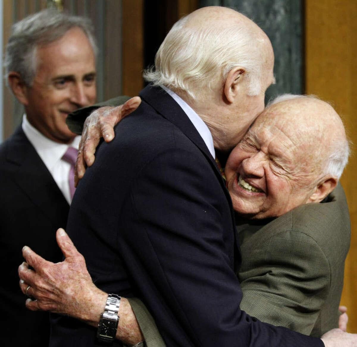 FILE - In this Wednesday, March 2, 2011, file photo, Senate Aging Committee Chairman Sen. Herb Kohl. D-Wis., center, gets a hug from entertainer Mickey Rooney, right, on Capitol Hill in Washington, as Sen. Bob Corker, R-Tenn., looks on at left, prior to Rooney testifying about elder abuse, before the committee. Rooney, a Hollywood legend whose career spanned more than 80 years, has died. He was 93. Los Angeles Police Commander Andrew Smith said that Rooney was with his family when he died Sunday, April 6, 2014, at his North Hollywood home. (AP Photo/Alex Brandon, File)