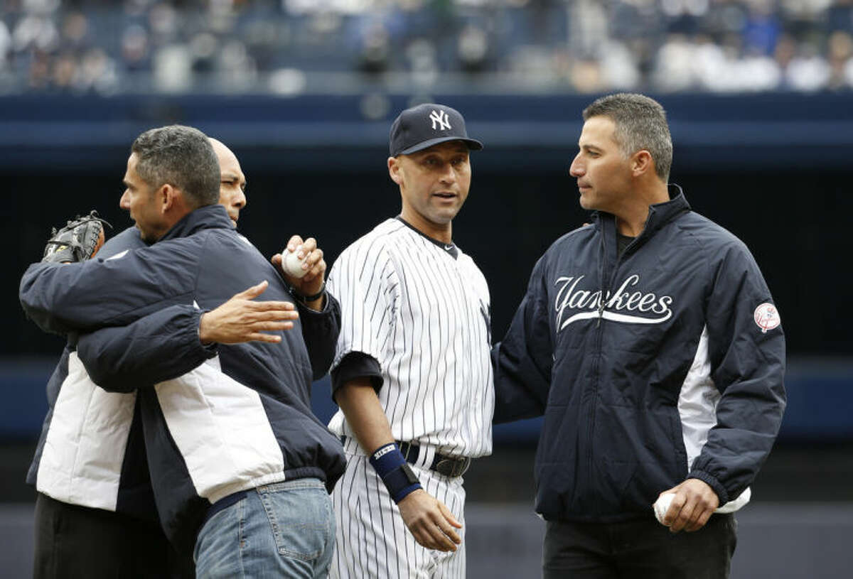 From left, former New York Yankees relief pitcher Mariano Rivera, former Yankees catcher Jorge Posada, New York Yankees shortstop Derek Jeter and former New York Yankees starting pitcher Andy Pettitte embrace after Rivera and Pettitte threw out the ceremonial first pitches to Posada and Jeter before the Yankees home opening baseball game against the Baltimore Orioles, at Yankee Stadium in New York, Monday, April 7, 2014. (AP Photo/Kathy Willens)