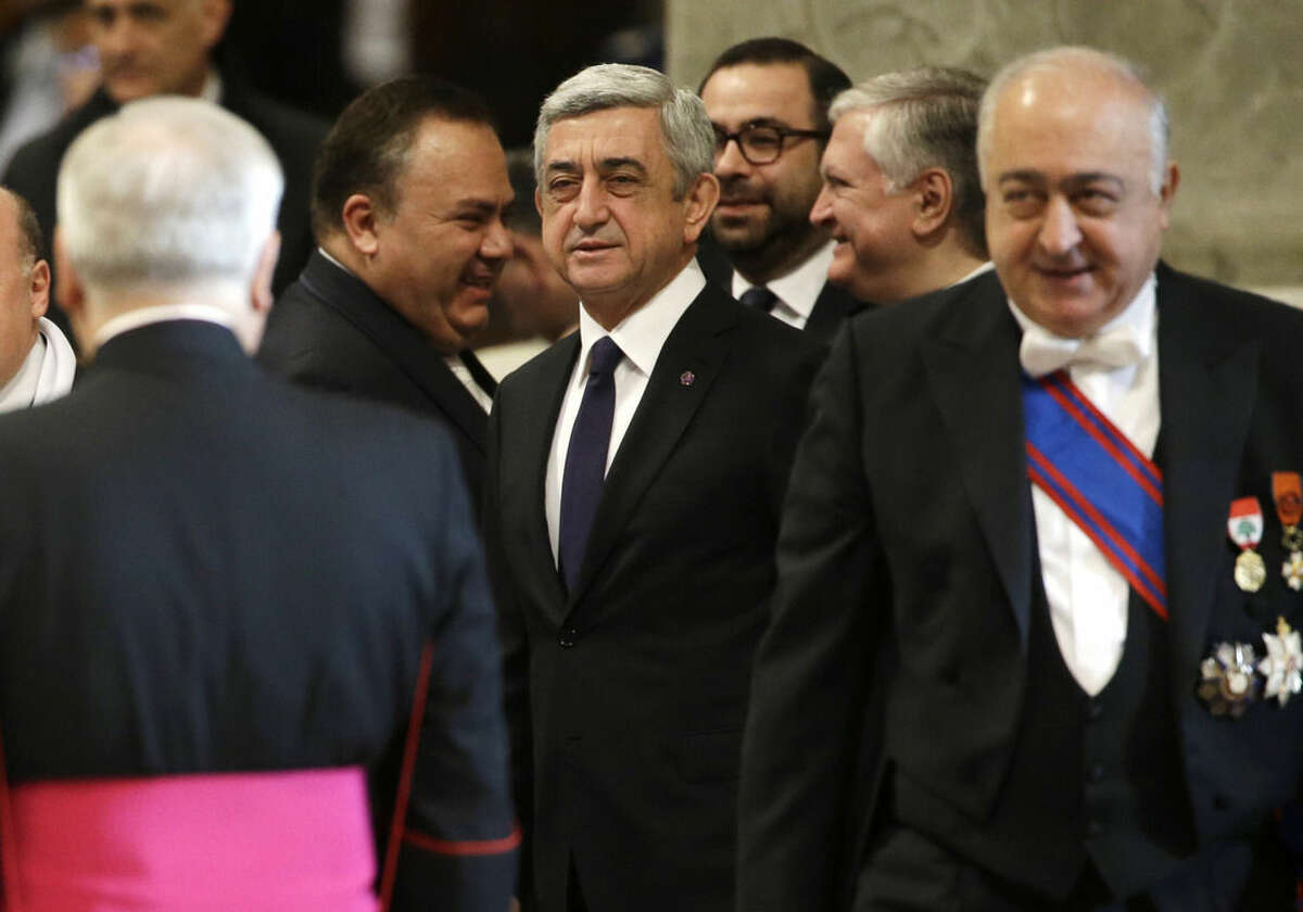 Armenian President Serzh Sargsyan, center, arrives to attend an Armenian-Rite Mass celebrated by Pope Francis on the occasion of the commemoration of the 100th anniversary of the Armenian Genocide, in St. Peter's Basilica, at the Vatican, Sunday, April 12, 2015. Historians estimate that up to 1.5 million Armenians were killed by Ottoman Turks around the time of World War I, an event widely viewed by genocide scholars as the first genocide of the 20th century. Turkey however denies that the deaths constituted genocide, saying the toll has been inflated, and that those killed were victims of civil war and unrest. (AP Photo/Gregorio Borgia)