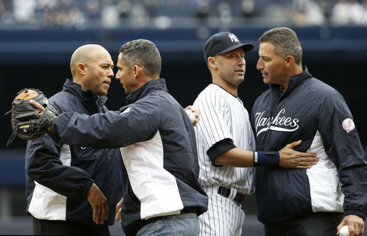From left, former New York Yankees relief pitcher Mariano Rivera, former Yankees catcher Jorge Posada, New York Yankees shortstop Derek Jeter and former New York Yankees starting pitcher Andy Pettitte embrace after Rivera and Pettitte threw out the ceremonial first pitches to Posada and Jeter before the Yankees home opening baseball game against the Baltimore Orioles, at Yankee Stadium in New York, Monday, April 7, 2014. (AP Photo/Kathy Willens)