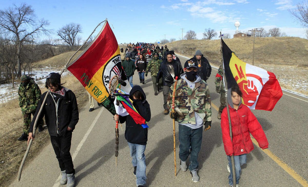 In this Feb. 27, 2014 photo, more than 100 people walk to Wounded Knee during the liberation anniversary of the famous massacre on the Pine Ridge Indian Reservation in South Dakota. Somewhere between 16,000 and 30,000 members of the Oglala Sioux Tribe live on the reservation which includes the county with the highest poverty rate in the U.S., and some of the worst rates of alcoholism and drug abuse, violence and unemployment. (AP Photo/Rapid City Journal, Chris Huber)