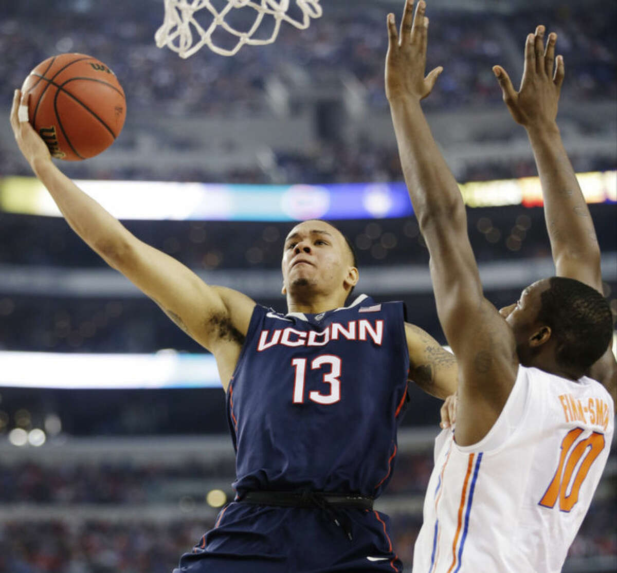 Connecticut guard Shabazz Napier (13) shoots as Florida forward Dorian Finney-Smith (10) defends during the first half of the NCAA Final Four tournament college basketball semifinal game Saturday, April 5, 2014, in Arlington, Texas. (AP Photo/David J. Phillip)