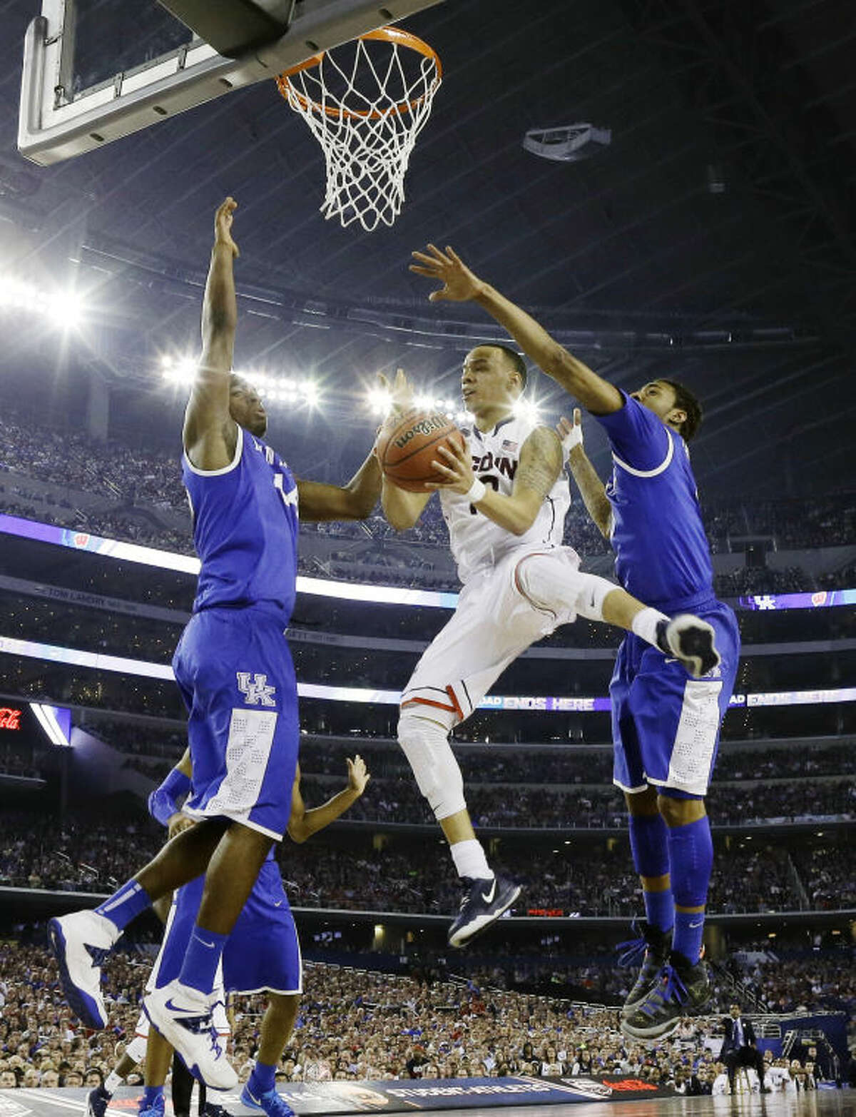 Connecticut guard Shabazz Napier shoots between Kentucky center Dakari Johnson (44) and guard James Young (1), right, during the first half of the NCAA Final Four tournament college basketball championship game Monday, April 7, 2014, in Arlington, Texas. (AP Photo/David J. Phillip)