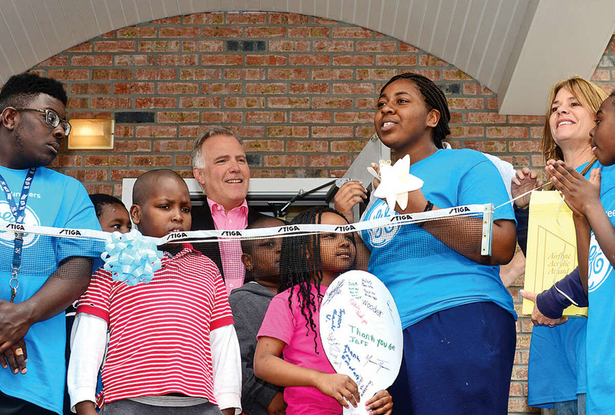 Hour photo / Erik Trautmann Alyah Fresnel makes a presentation of gratitude during the Norwalk Grass Roots Tennis ribbon-cutting ceremony for the new headquarters and youth center at the old Nathaniel Ely School at 11 Ingalls Ave. Friday. GE Capital volunteers spent three days renovating the space ready for grand opening.