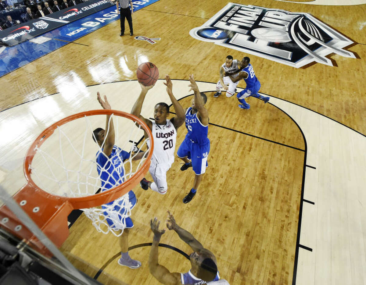 Connecticut guard Lasan Kromah (20) shoots between defenders Kentucky forward Marcus Lee (00) and guard Aaron Harrison (2) during the first half of the NCAA Final Four tournament college basketball championship game Monday, April 7, 2014, in Arlington, Texas. (AP Photo/Chris Steppig, pool)