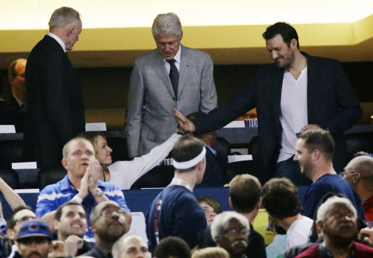 From left, Dallas Cowboys owner Jerry Jones, former president Bill Clinton, and Cowboys quarterback Tony Romo take their seats to watch Connecticut and Kentucky during the first half of the NCAA Final Four tournament college basketball championship game Monday, April 7, 2014, in Arlington, Texas. (AP Photo/David J. Phillip)