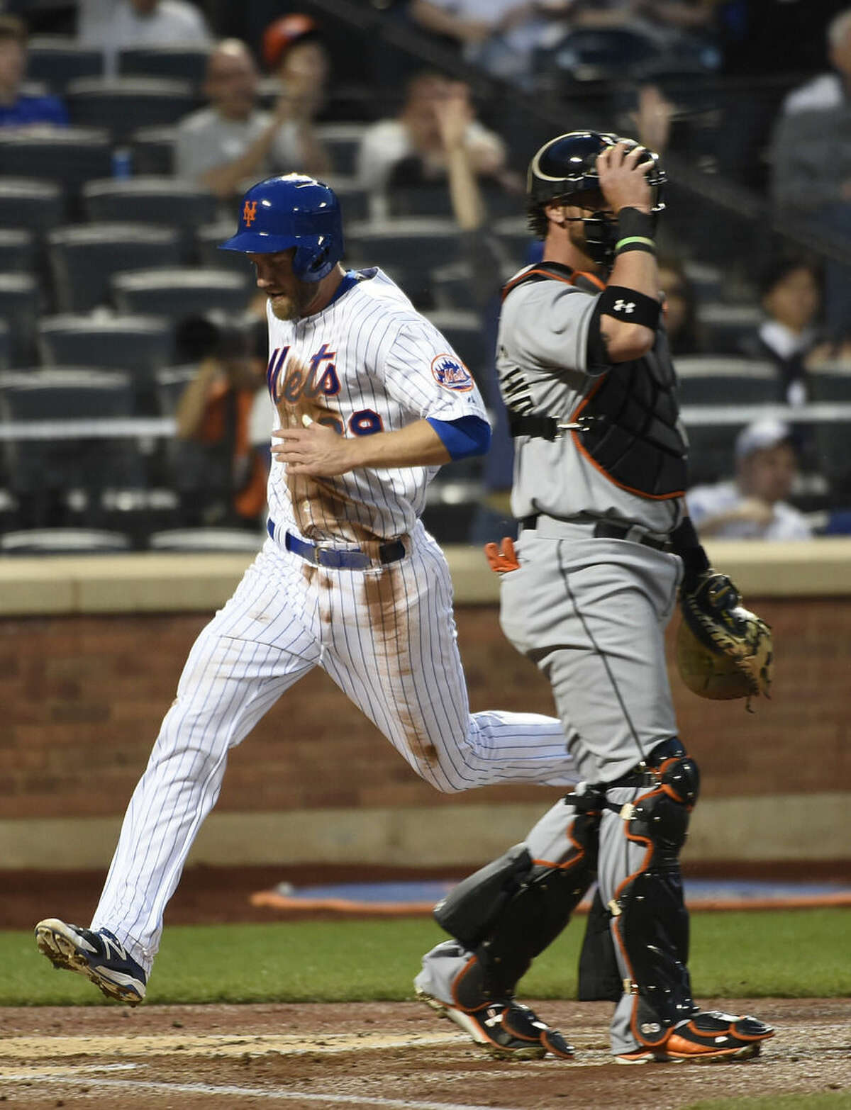 New York Mets' Eric Campbell, left, scores at home plate behind Miami Marlins catcher Jarrod Saltalamacchia on an RBI-single by Juan Lagares in the second inning of a baseball game at Citi Field on Saturday, April 18, 2015, in New York. (AP Photo/Kathy Kmonicek)