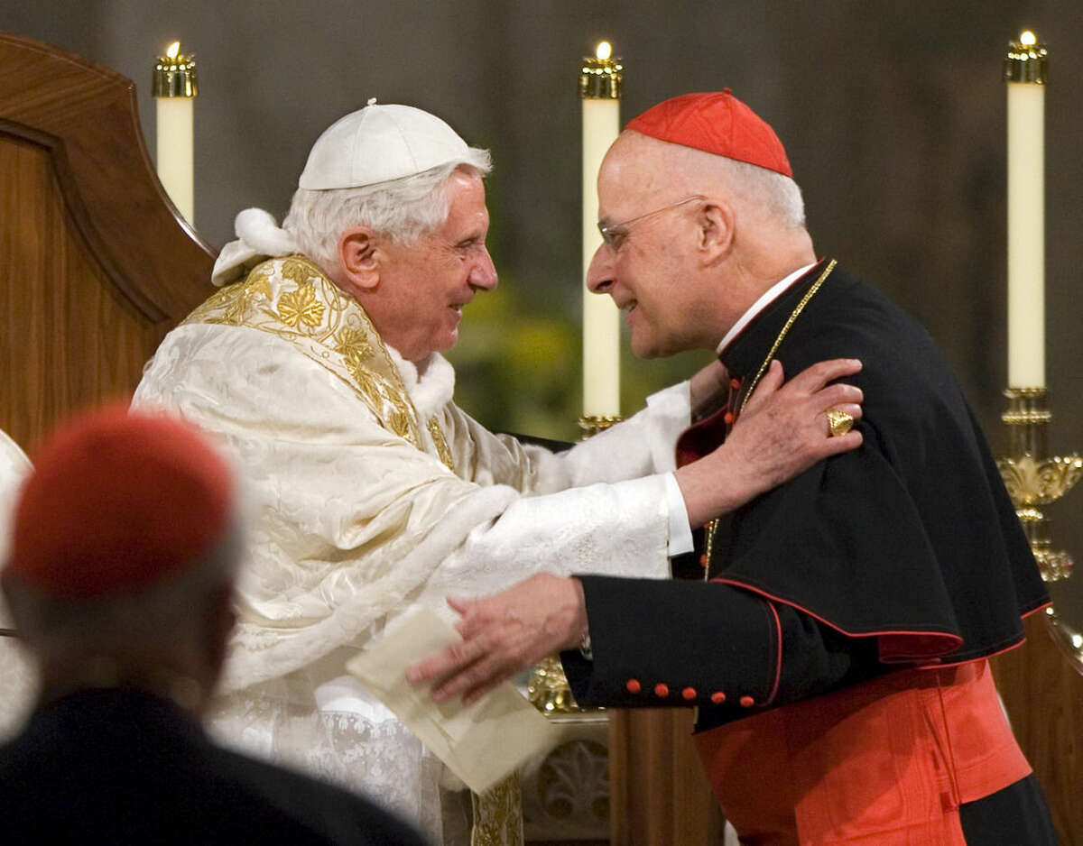 FILE -- In this April 16, 2008 file photo Pope Benedict XVI embraces Chicago's Cardinal Francis George after addressing the bishops at the Basilica of the National Shrine of the Immaculate Conception in Washington. Cardinal Francis George, a vigorous defender of Roman Catholic orthodoxy who played a key role in the church's response to the clergy sex abuse scandal, has died. He was 78. (AP Photo/J. Scott Applewhite)