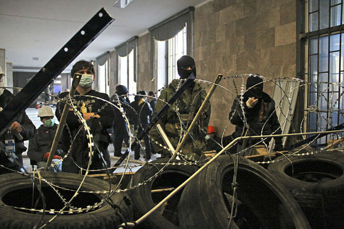 Activists prepare a barricade inside the regional administration building in Donetsk, Ukraine, Monday, April 7, 2014. A Ukrainian news agency is reporting that pro-Russian separatists who have seized the regional administration building in the eastern Ukrainian city of Donetsk proclaimed the region an independent republic. The activists on Monday also called for a referendum on the sovereignty of the Donetsk region, which borders Russia, to be held no later than May 11, the Interfax news agency reported.(AP Photo/Alexander Ermochenko)