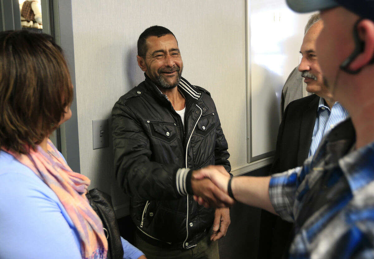 Ahmad al-Abboud, center, shakes hands with a reporter following a news conference at Della Lamb Community Services in Kansas City, Mo., Monday, April 11, 2016. Ahmad al-Abboud and his family are the first Syrian family to be resettled in the U.S. under a speeded-up "surge operation" for refugees. (AP Photo/Orlin Wagner)