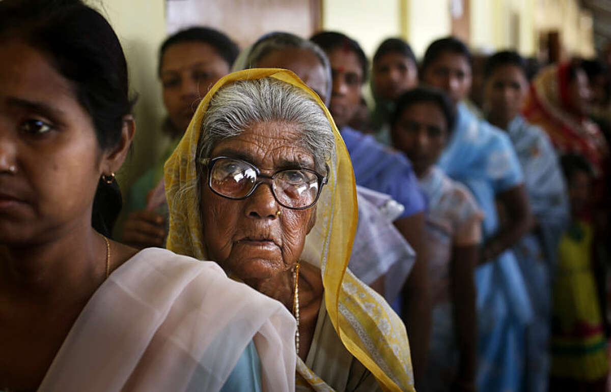 An elderly Indian woman watches as she stands in a queue to cast her vote during the first phase of elections in Dibrugarh, in the northeastern state of Assam, India, Monday, April 7, 2014. India started the world's largest election Monday, sealing international borders along its remote northeast while voters made their way past lush rice paddies and over rickety bamboo bridges and pot-holed dirt roads to reach the polls. The country's 814 million eligible voters will vote in stages over the next five weeks. (AP Photo/Altaf Qadri)