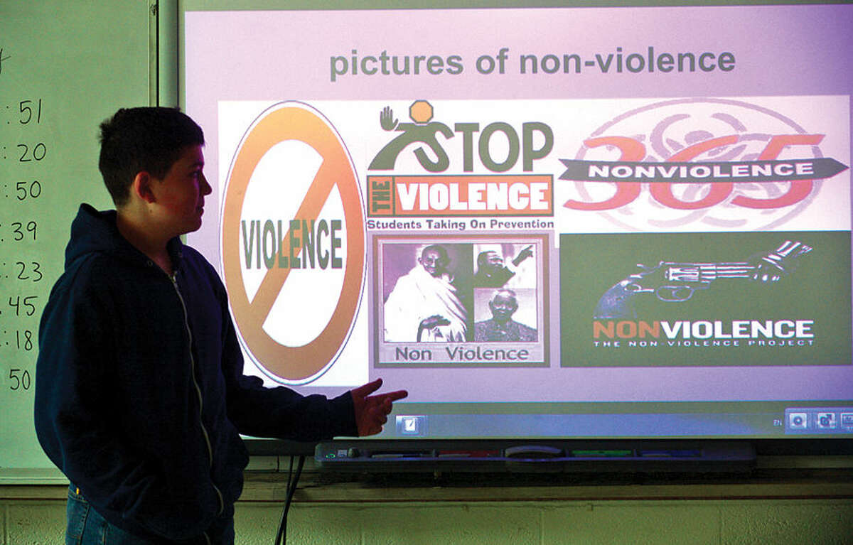 Hour photo / Erik Trautmann West Rocks Middle School student Andrew Romaniello speaks about his pictures of non-violence project during the program titled “Safe, Peaceful and Non-Violent West Rocks Community” Friday morning. The program is a part of Positive Behavior Intervention Supports (PBIS), a statewide program to encourage positive behavior in students.
