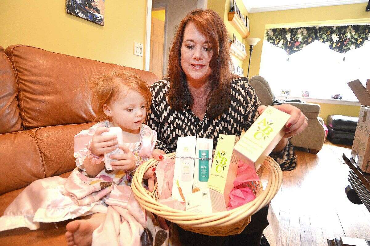 Hour Photo/Alex von Kleydorff Kristin Kreuder Overton gets help from her 2 yr old daughter Victoria, making baskets full of personal care items for distribution on Mothers day to Malta House