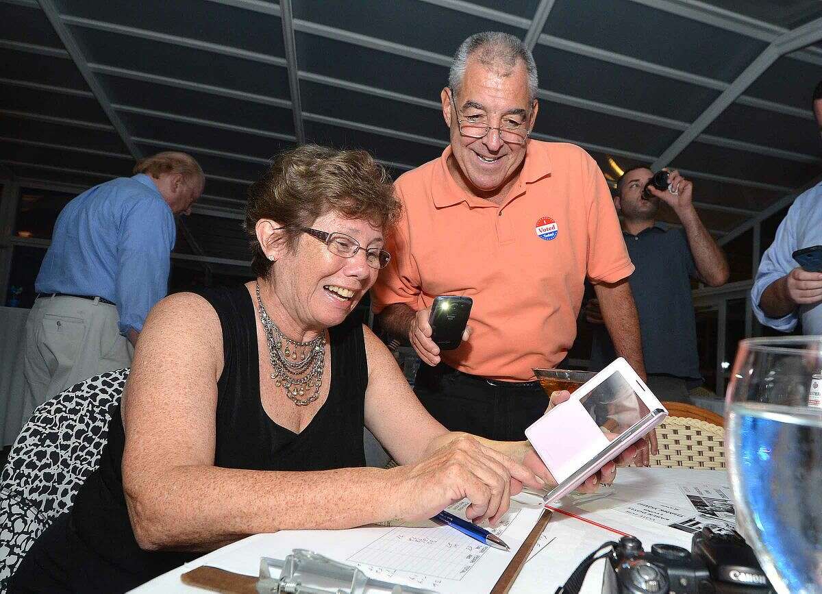 Hour Photo/Alex von Kleydorff Karen Doyle-Lyons smiles as numbers come in with help from Lou DePanfilis and his smart phone flashlight at The Norwalk Inn.