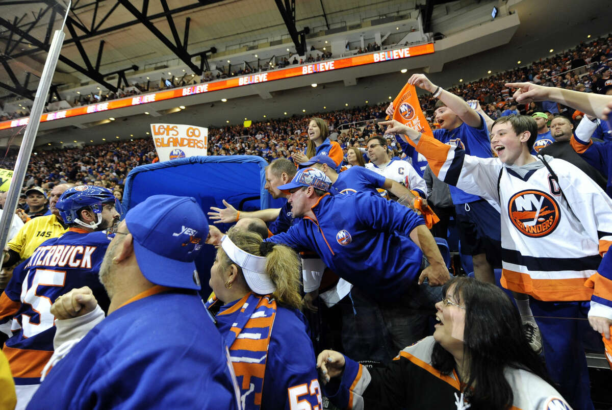 New York Islanders fans cheer New York Islanders right wing Cal Clutterbuck (15) and teammates as they leave the ice after beating the Washington Capitals 3-1 in Game 6 of a first-round NHL Stanley Cup hockey playoffs at Nassau Coliseum on Saturday, April 25, 2015, in Uniondale, N.Y. (AP Photo/Kathy Kmonicek)