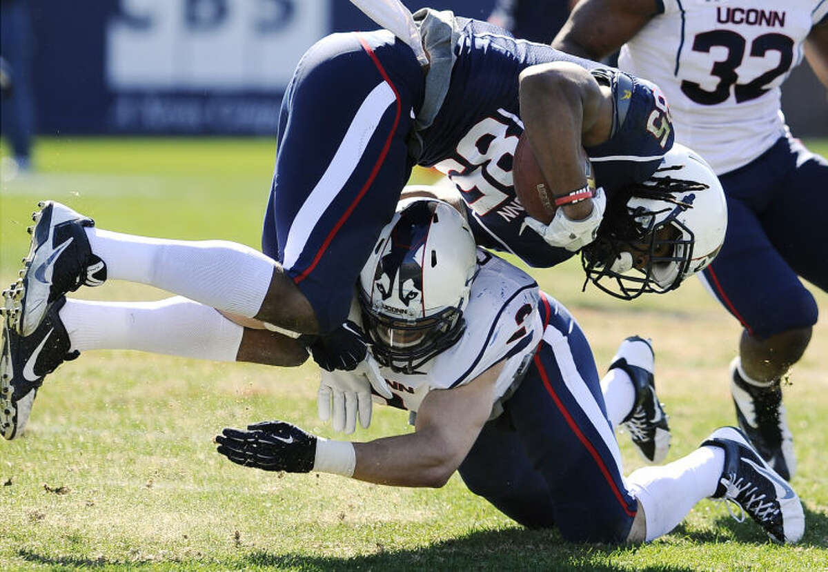 Connecticut blue teams's Geremy Davis, top, is tackled by white's Graham Stewart during the first half of UConn's Blue-White spring NCAA college football game at Rentschler Field, Saturday, April 12, 2014, in East Hartford, Conn. (AP Photo/Jessica Hill)