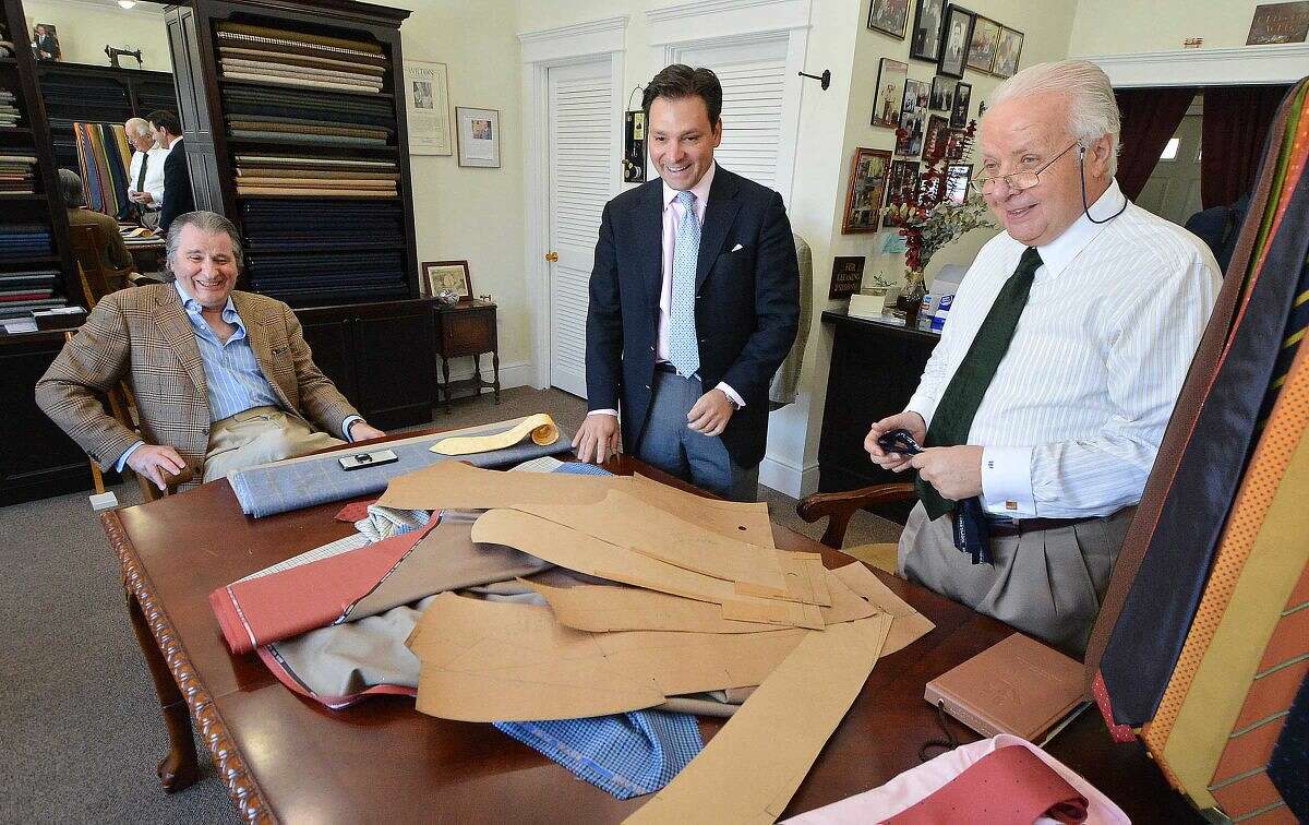 Umbeto Pitagora and clients Thomas Vozzella and Gene Venanzi share a laugh looking over the pattern for Vozzella's suit, which Umberto custom tailors with one arm longer by an inch because of years of playing golf.