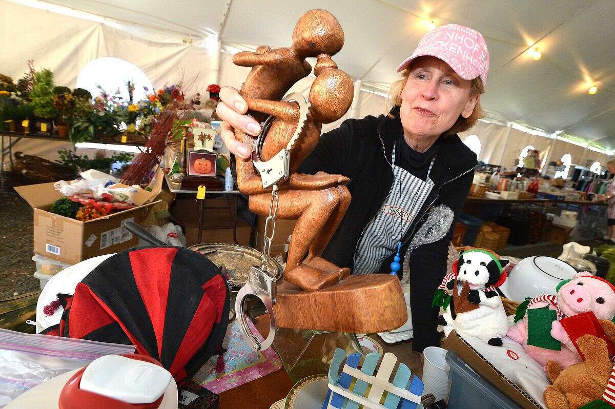 Volunteer Susan Florido organizes some of the items such as a free-form sculpture — handcuffs extra — for the upcoming Minks to Sinks Sale.