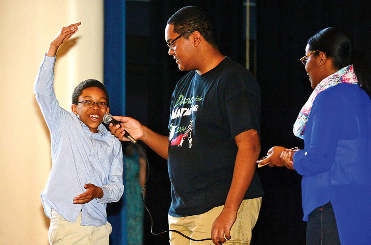 Hour photo / Erik Trautmann Nathan Hale Middle School 6th grader Allen Counts answers a question on bullying from Norwalk High School Peace Works program members Daniel Smith and Seliana Seradieau as they make a anti-bullying presentation to students at the middle school Thursday.