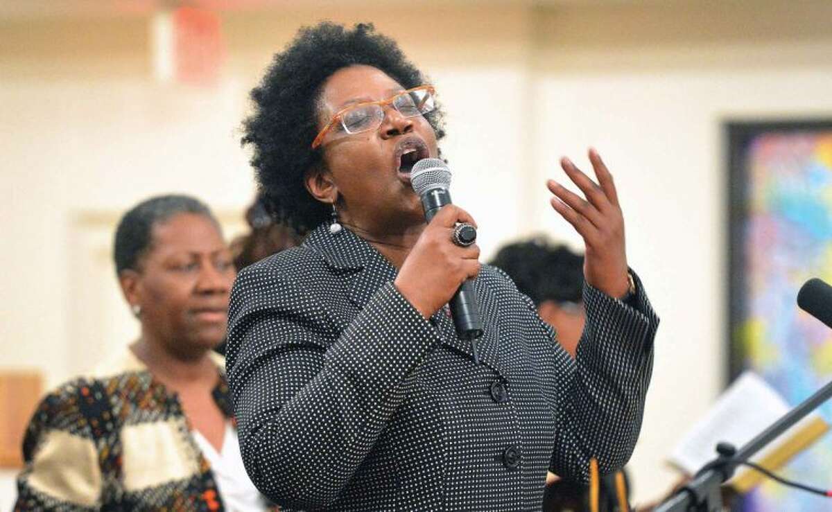 Hour Photo/Alex von Kleydorff . Reverend Dawn C. Snell leads the Friendship Baptist Church of Stamford in the song, Near The Cross, during a a special service, 'Seven Women at The Cross' on Wednesday night