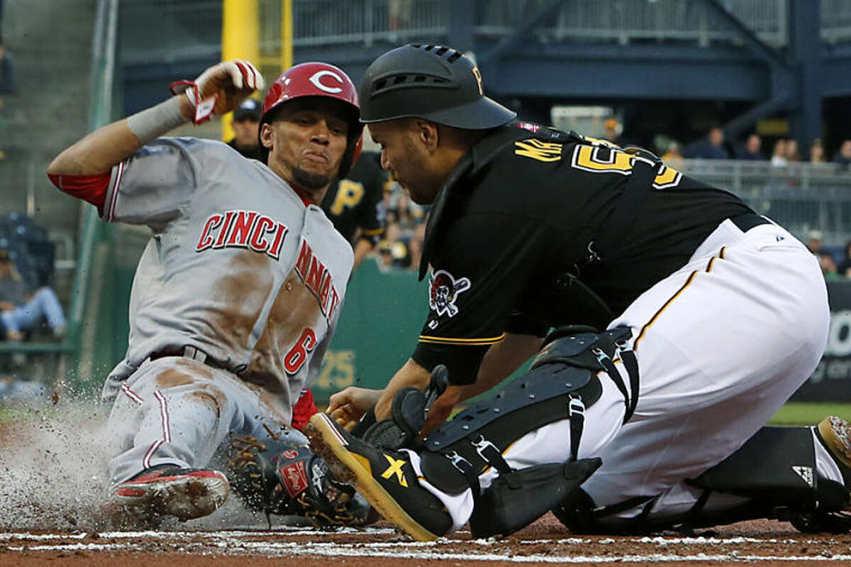 Cincinnati Reds' Billy Hamilton (6) scores ahead of the tag by Pittsburgh Pirates catcher Russell Martin (55) during the first inning of a baseball game in Pittsburgh Monday, April 21, 2014. Hamilton scored on a fielder's choice by teammate Brandon Phillips. (AP Photo/Gene J. Puskar)