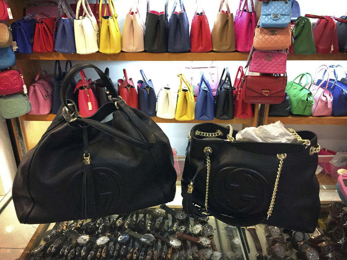 In this March 11, 2015 photo, counterfeit branded bags appear on display in a room hidden from the public area of a popular shopping mall in Beijing. A review of hundreds of pages of court documents from cases in the United States and China, along with interviews with lawyers, investigators, government officials and industry representatives, show that a lack of legal cooperation between the West and China is allowing counterfeiters to use Chinese banks as financial shelters. (AP Photo/Mark Schiefelbein)