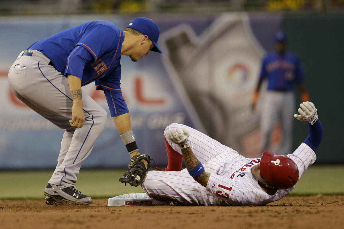Philadelphia Phillies' Freddy Galvis, right, steals second base under the tag from New York Mets shortstop Wilmer Flores during the third inning of a baseball game, Friday, May 8, 2015, in Philadelphia. (AP Photo/Matt Slocum)