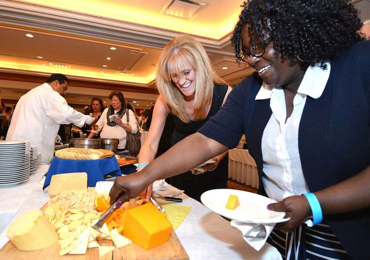 Hour Photo/Alex von Kleydorff Sheri Gradia and Juanita Sanford sample some cheeses at the buffet during the Silent Auction and Wine Tasting to benefit the PAL, Police Athletic League program at the Norwalk Police Department