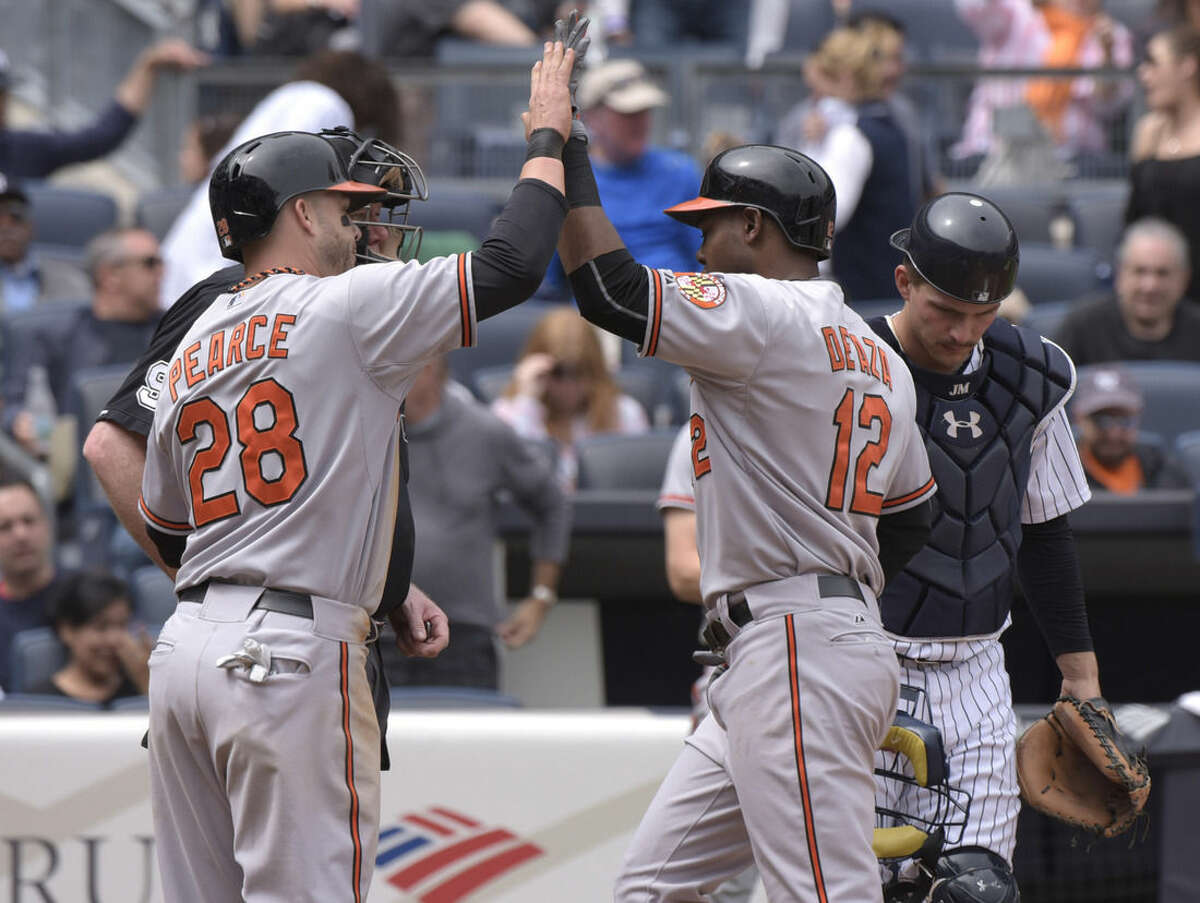 Baltimore Orioles' Alejandro De Aza celebrates with Steve Pearce, left, after De Aza hit a two-run home run as New York Yankees catcher John Ryan Murphy, right, reacts during the fourth inning of a baseball game against the New York Yankees Saturday, May 9, 2015, at Yankee Stadium in New York. (AP Photo/Bill Kostroun)