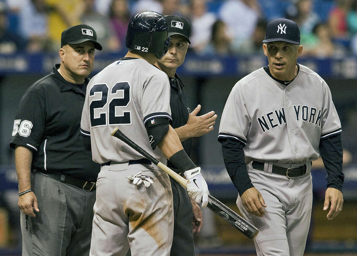 New York Yankees' Jacoby Ellsbury (22) and manager Joe Girardi, right, argue a call with umpires Eric Cooper (56) and Dan Iassogna, center, during the eighth inning of a baseball game Tuesday, May 12, 2015, in St. Petersburg, Fla. (AP Photo/Steve Nesius)