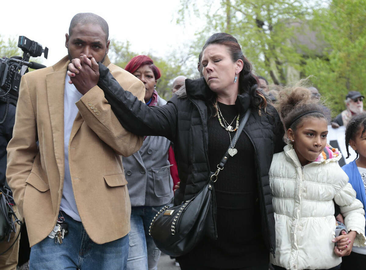 Jeff Jackson, left, comforts his girlfriend, Andrea Irwin, the mother of Tony Robinson, while escorting her during a protest march on Williamson Street, Tuesday, May 12, 2015, in Madison, Wis. Dane County District Attorney Ismael Ozanne announced Tuesday that Madison Police Officer Matt Kenny would not face charges for the shooting death of Robinson. (M.P. King/Wisconsin State Journal via AP)