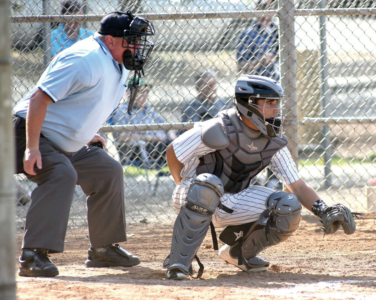 Home plate umpire Bob Victory, left, and Norwalk catcher Marco Monteiro await the next pitch during Monday’s game against Stamford. (Hour photo/John Nash)