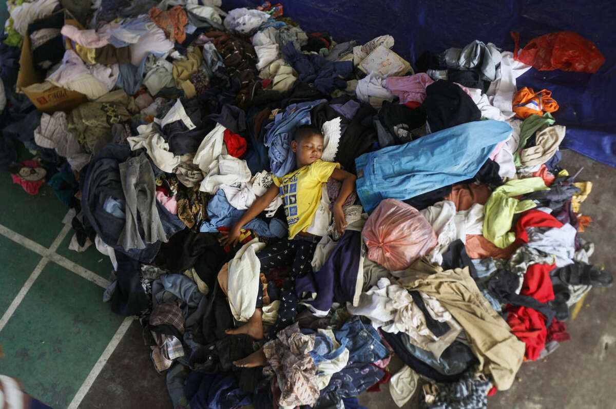 An ethnic Rohingya boy sleeps on a pile of used clothing donated by local residents at a sports stadium turned into temporary shelter for migrants whose boats washed ashore on Sumatra island on Sunday, in Lhoksukon, Aceh province, Indonesia, Wednesday, May 13, 2015. Abandoned at sea, thousands of Bangladeshis and members of Myanmar's long-persecuted Rohingya Musilm minority appear to have no place to go after two Southeast Asian nations refused to offer refuge to boatloads of hungry men, women and children. (AP Photo/Binsar Bakkara)