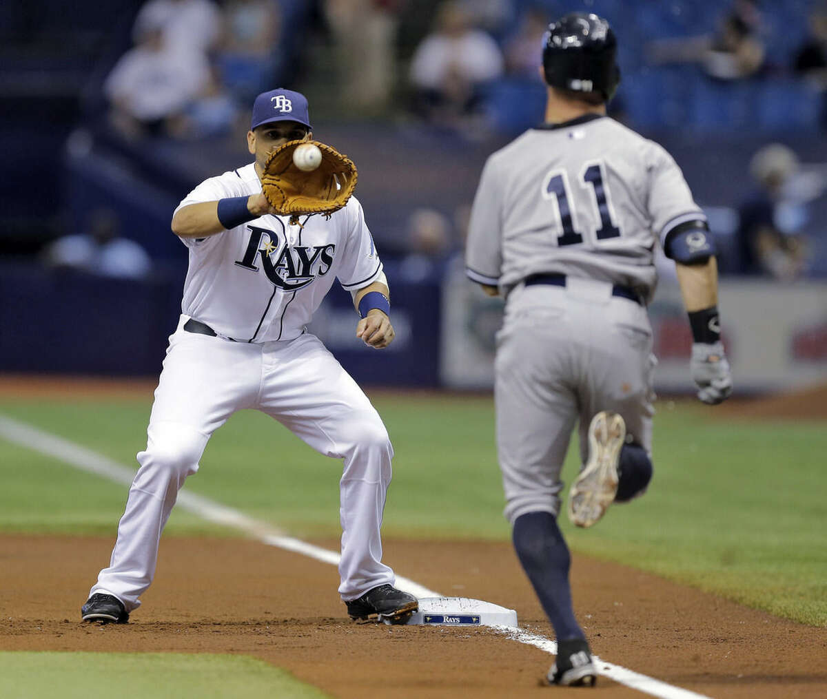 Tampa Bay Rays first baseman James Loney gets the throw from catcher Rene Rivera for the out on New York Yankees' Brett Gardner (11) at first base on a sacrifice bunt during the first inning of a baseball game Thursday, May 14, 2015, in St. Petersburg, Fla. Jacoby Ellsbury advanced to second on the play. (AP Photo/Chris O'Meara)