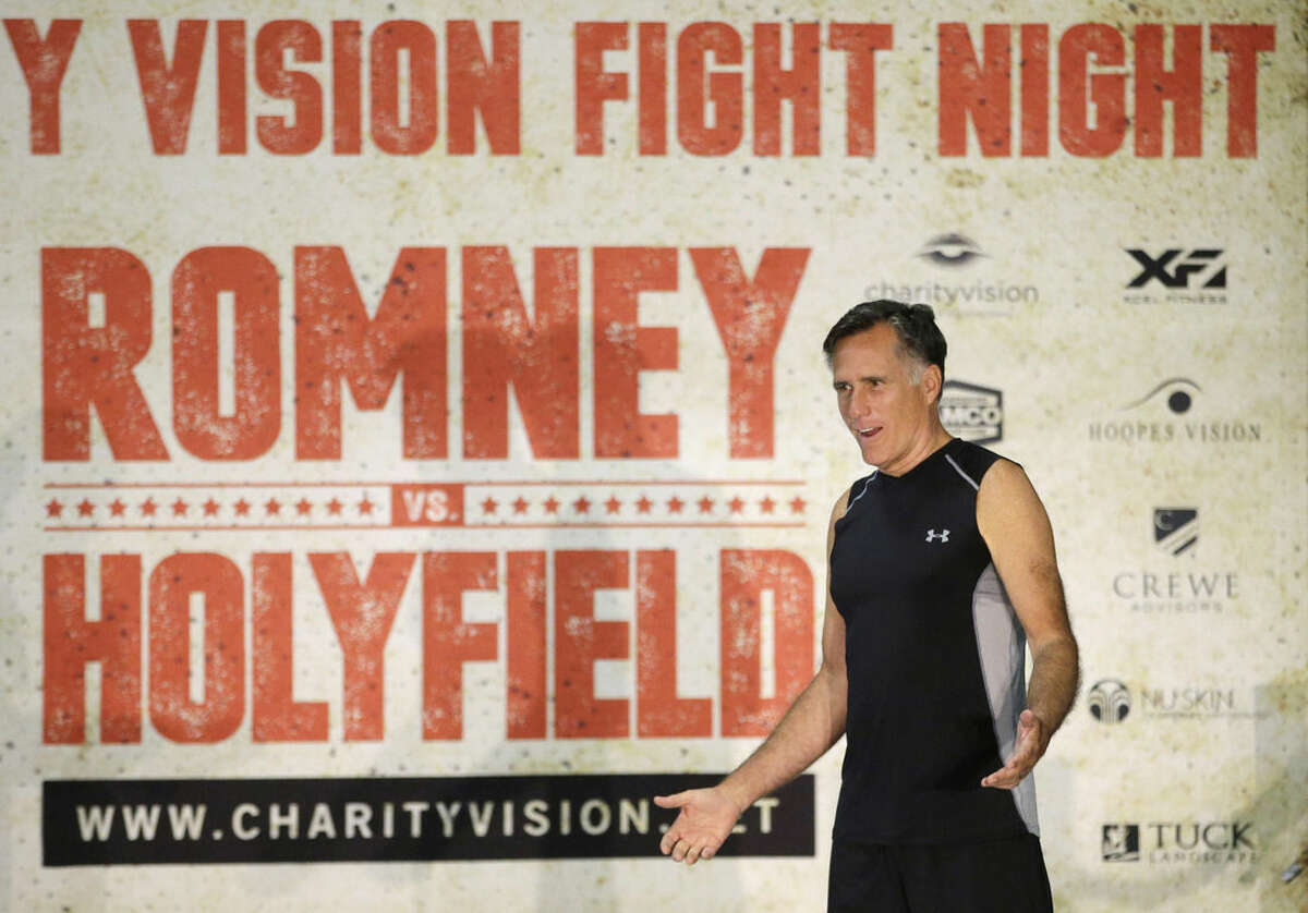 Former Republican presidential candidate Mitt Romney talks during an official weigh-in with five-time heavyweight boxing champion Evander Holyfield, Thursday, May 14, 2015, in Holladay, Utah. Romney and Holyfield are set to square off at a charity fight on Friday, May 15, in Salt Lake City. The black-tie event will raise money for the Utah-based organization CharityVision, which helps doctors in developing countries perform surgeries to restore vision in people with curable blindness. (AP Photo/Rick Bowmer)