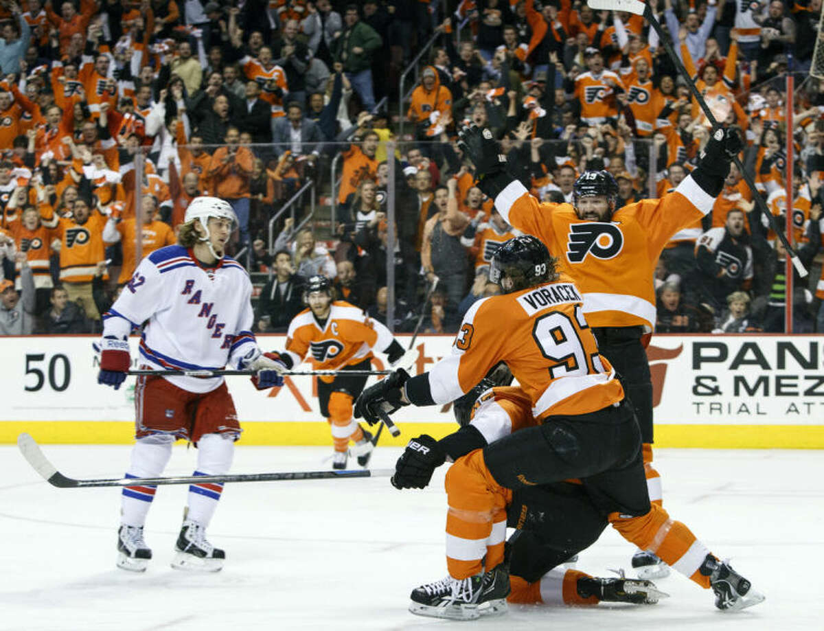 Philadelphia Flyers' Wayne Simmonds, center, celebrates his goal with Jakub Voracek, second from right, of Czech Republic and Scott Hartnell, right, as New York Rangers' Carl Hagelin, left, of Sweden, skates by during the first period in Game 6 of an NHL hockey first-round playoff series, Tuesday, April 29, 2014, in Philadelphia. (AP Photo/Chris Szagola)